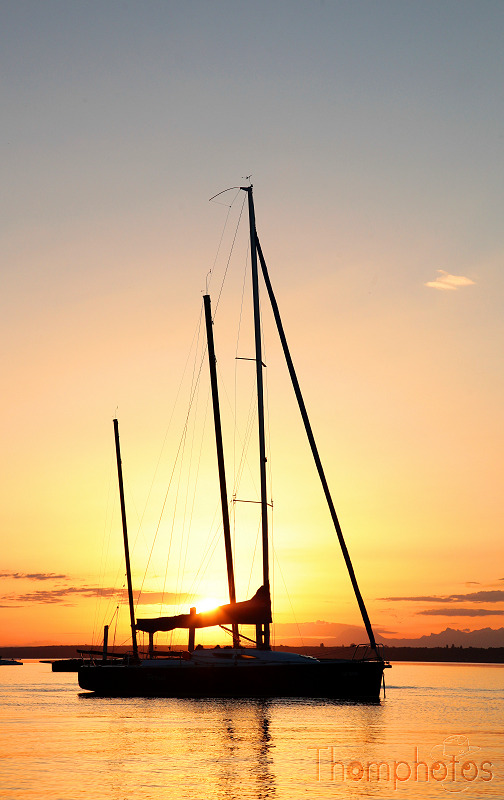 paysage versoix lac léman de genève levé de soleil couleur orange lumière réveil été chaleur reflets dorés bateau contre jour ombre chinoise navire voilier